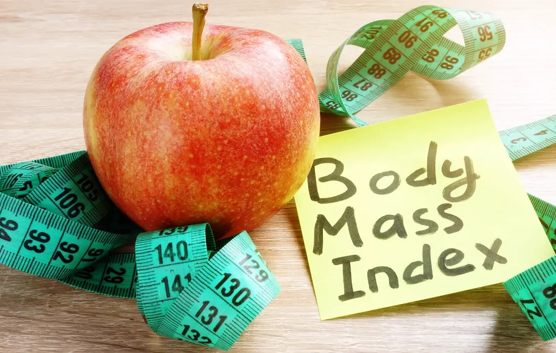 Body mass index bmi written on a memo stick and apple